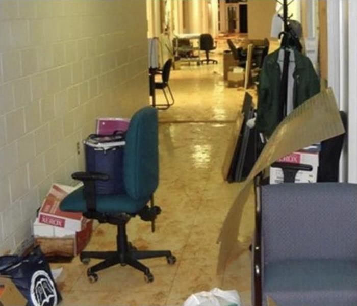 Office furniture in the corridor of a building, floor is wet and with mud