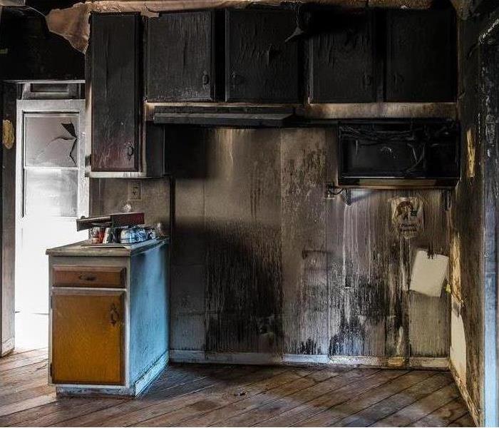 Cabinets and walls of a kitchen black, damaged by fire. Concept of fire damage in a kitchen